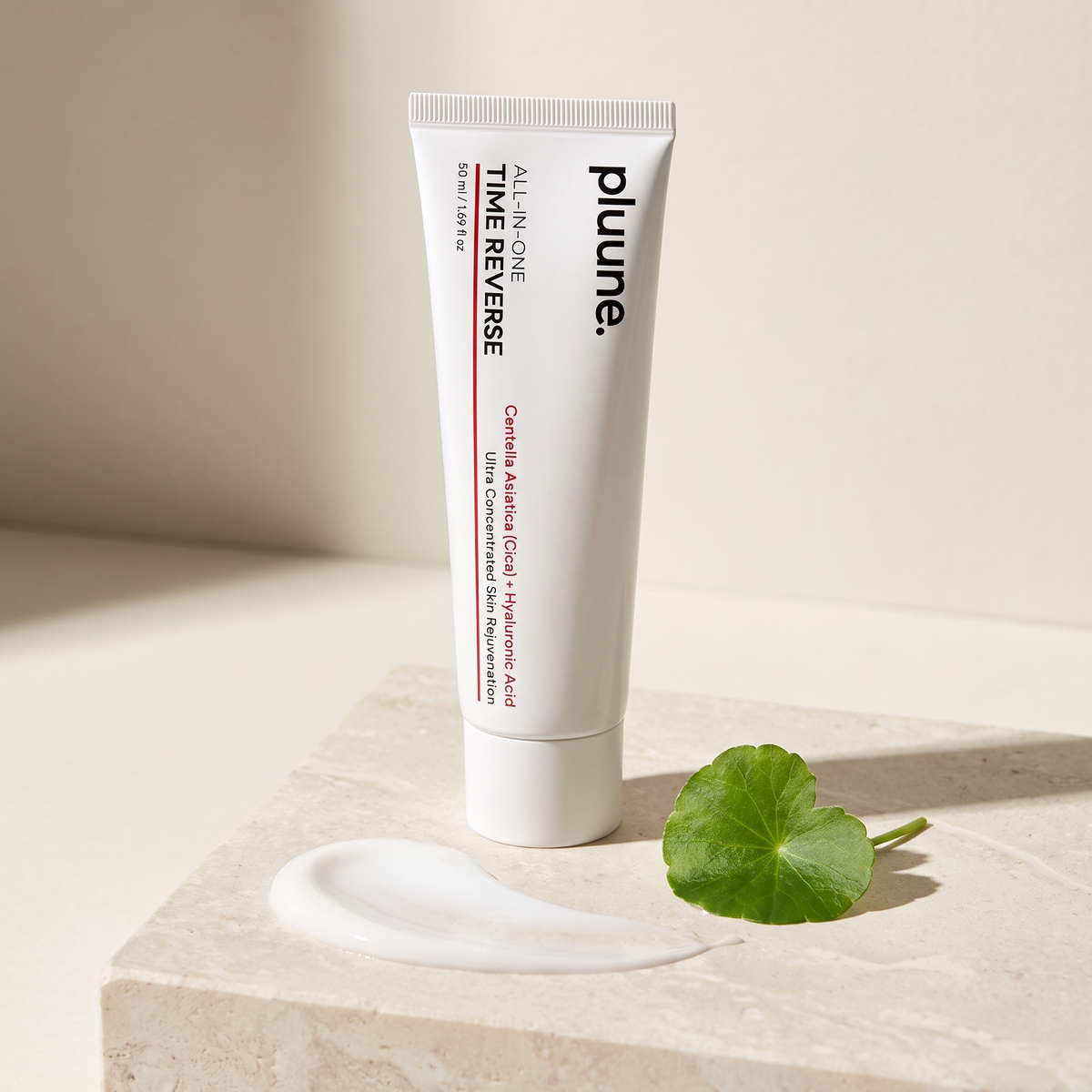 Pluune Time Reverse cream tube standing on a stone block with a swatch of white cream and a green centella leaf