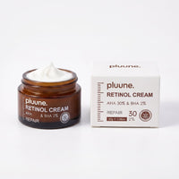 Pluune Retinol Cream in an open amber glass jar next to its white box labeled AHA 30% & BHA 2%